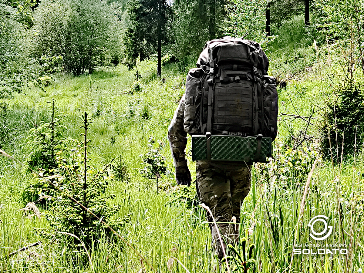 Voják s batohem Snigel na zádech, pohled ze zadu. 