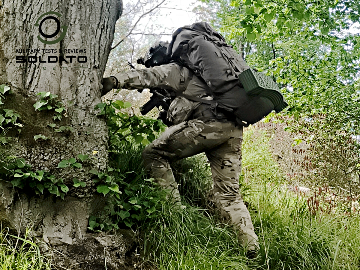 Voják v uniformě multicam šplhá v náročném terénu s batohem Snigel 100l na zádech. 