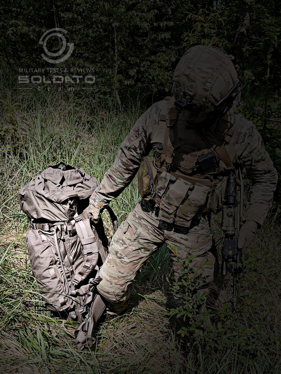 Voják bere batoh Snigel 100l za zadní poutko. 